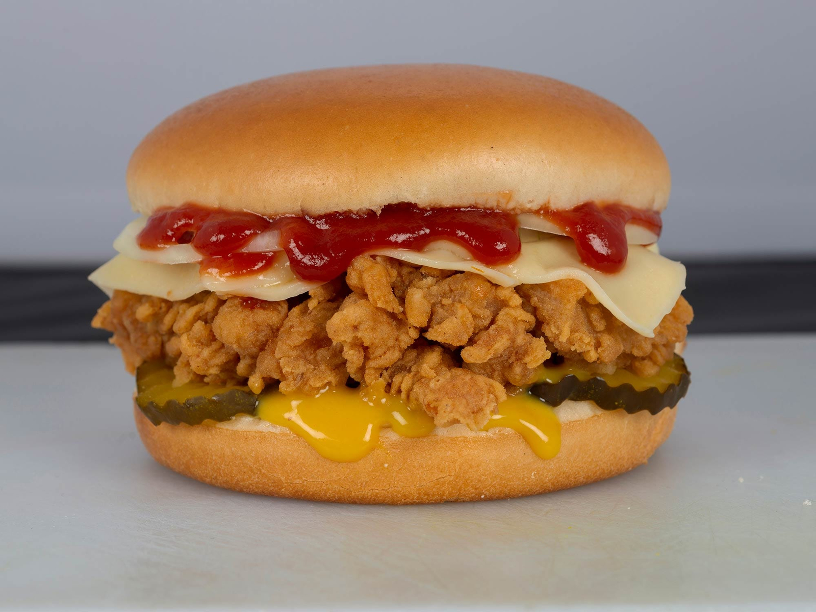 Kfc-antes Fotografía profesional de hamburguesa con pollo frito y queso, antes y después de edición