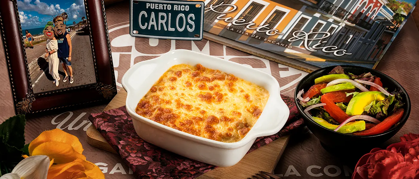 Plato gratinado tipo lasaña en recipiente blanco con ensalada fresca, fotografía gastronómica en mesa decorada