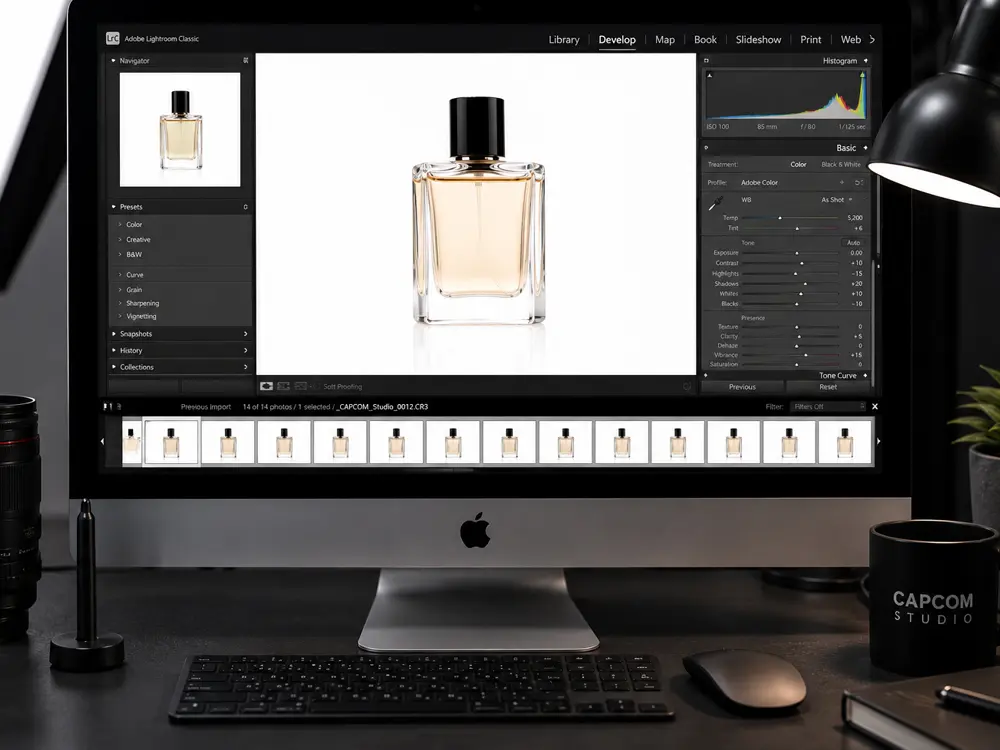 Edición profesional de fotografía de perfume en computador Mac con corrección de color y selección de imágenes para e-commerce.